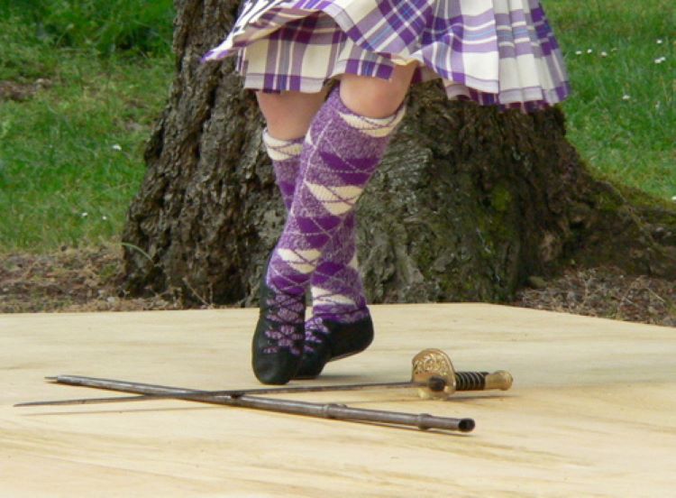 A highland dancer dancing a sword dance in a competition