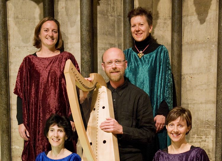 4 female singers flanking a seated male harpist holding a medieval harp, photographed in York Minster
