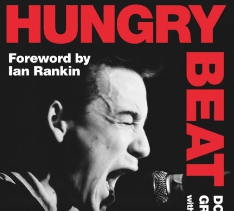 book cover title 'Hungry Beat' with a foreward by Ian Rankin. A male punk rock musician singing into a microphone, with his eyes shut and clearly singing loudly.