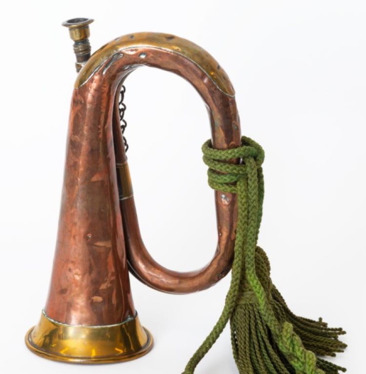 a small brass bugle with a green regimental cord