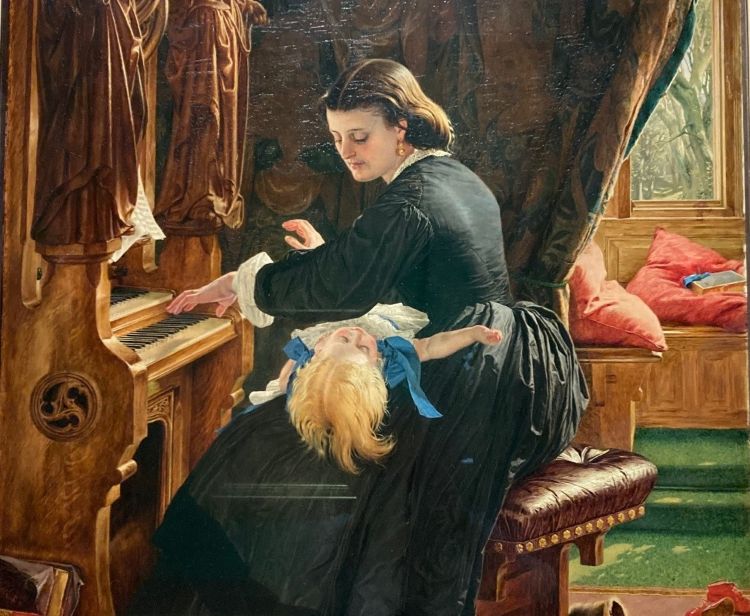 A woman in a black dress playing the organ with a child on her lap. Rich drapes behind her and a window with cushions